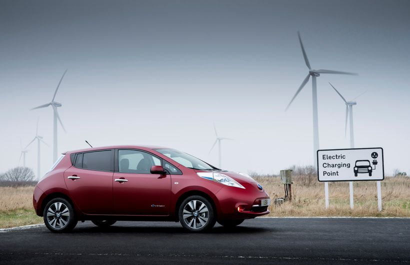 Red Nissan Leaf parked at electric charging point